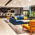 Courtyard by Marriott San Salvador lobby lounge with bar, blue sofa and yellow chairs in San Salvador