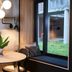 Hotel Guestapart in Aarhus dining nook with round table, plant, black chairs and window seat