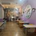 Milano Ostello dining room in Milan with purple walls, tables, chairs and a mural