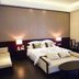 Yushuigu Hot Spring Hotel in Maoming guest room with bed, sofa, side lamps and small table