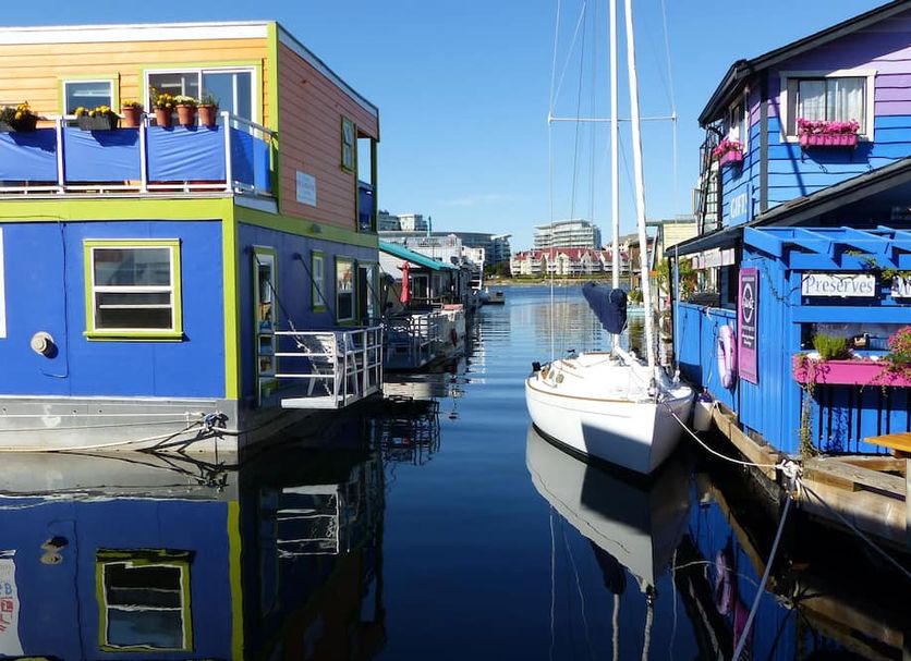 Fisherman's Wharf Bed & Breakfast in Victoria, floating colorful houseboats beside a sailboat on calm water