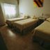 Tagüe in Gualeguaychú: guest room with three single beds and a window with sheer curtains