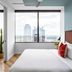 Mint House Dallas Downtown By Kasa room with city skyline view through large window in Dallas