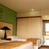 Garden Hotel in Campina Grande guest room with two beds, green wall art, and a mirror