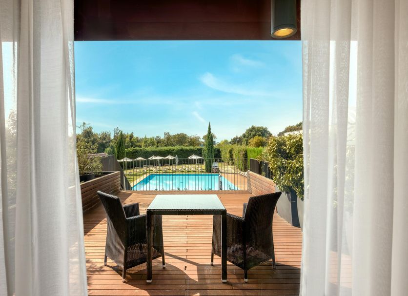 Hilton Garden Inn Venice Mestre San Giuliano terrace with table, chairs, and pool view in Venice