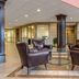 Lobby seating area at Quality Hotel Conference Center Cincinnati Blue Ash in Cincinnati with leather chairs and glass table