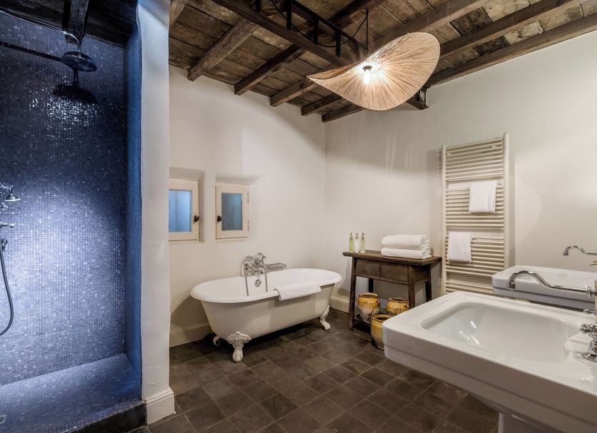 Les Petites Maisons - Hameau des Baux bathroom in Paradou with freestanding tub, shower and stone floor