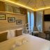 Kausar Hotel in Bishkek guest room with bed, TV, chair, and balcony door