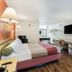 Motel 6 Newport News, VA room with queen bed, desk, wall-mounted TV and wood-look flooring