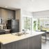 Solo Suites in Victoria: modern suite kitchen with island, black appliances, and bright dining area