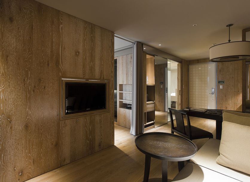 Gloria Residence Taipei City suite with wood-paneled walls, seating area, and TV