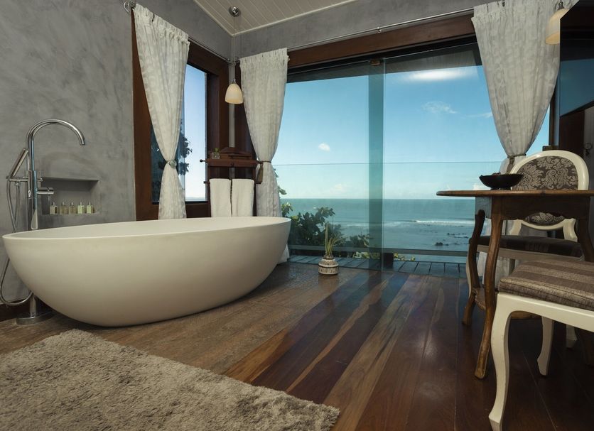 Boutique Hotel Marlin's in Tibau do Sul bathroom with freestanding tub and ocean-view window