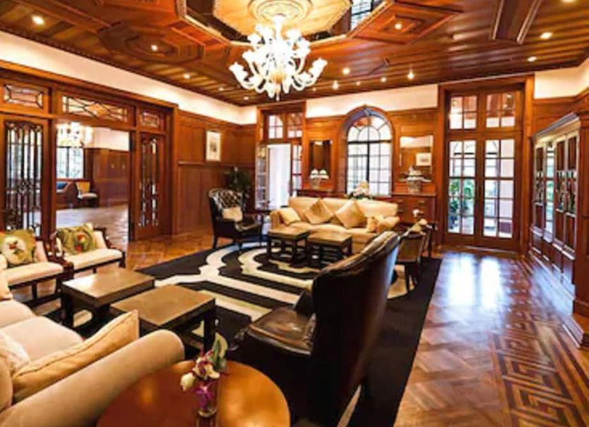 Moller Villa Hotel Shanghai lounge with chandelier, wood-paneled ceiling, sofas, and ornate windows