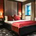 The Torrance Hotel Glasgow bedroom with king bed, red accents and ensuite bathroom
