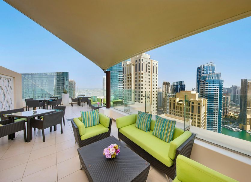 Hilton Dubai The Walk rooftop terrace with seating and panoramic Dubai skyline views
