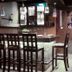 Zawadi House Arusha bar area with high stools, hanging lights, and glass display cabinets
