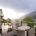 The Whispering Pine Lodge in Spean Bridge features a lake-view balcony with wicker seating and mountain views.