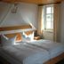 Bayerischer Hof Münnerstadt guest room with twin beds, window light and framed wall art