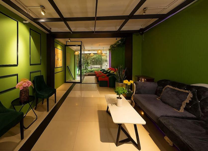 Hoang Phi Hotel in Ho Chi Minh City lobby seating area with green walls and black sofas