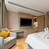 Home2 Suites by Hilton Xishuangbanna Jinghong room with bed, armchair, and TV in Xishuangbanna