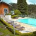 Plaza Inn Week Inn in Campos do Jordão with an outdoor pool and lounge chairs amid forest views