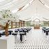 Hanbury Manor Marriott Hotel & Country Club in Ware: elegant wedding reception tent with white drapes and black chairs