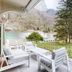 Grand Hotel des Bains in Lavey-Morcles balcony with white seating overlooking mountain and garden views
