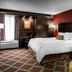 Hampton Inn Nashville-Vanderbilt guest room with king bed, red accent wall, and patterned armchair in Nashville