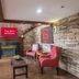Red Roof Inn & Suites Stafford, VA - Quantico lobby with fireplace, red chairs, and staircase in Stafford