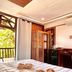 Patrick's on the Beach Resort, General Luna: beachside room with balcony, bed, and tropical view