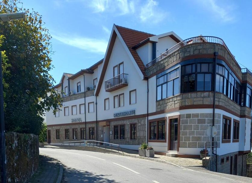 Hotel Boavista I in Melgaço, exterior with curved glass corner and hillside street view