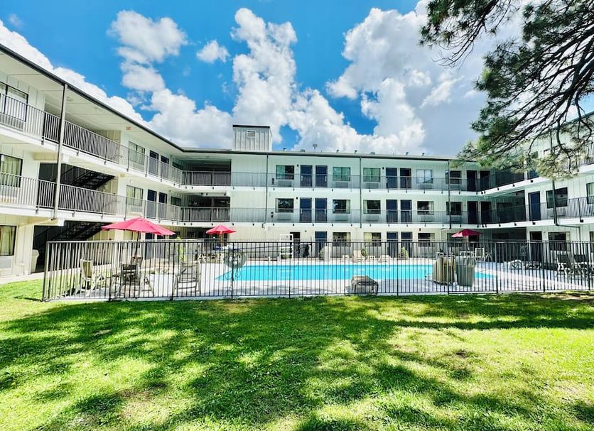 Motel 6-Flagstaff, AZ - West - Woodland Village courtyard pool with three-story motel and lawn