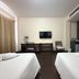 Baan Suksiri Hotel Hua Hin twin room with two beds, desk, TV, and large curtains