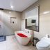 Fullmoon Villa Ubud bathroom with freestanding tub, shower, and window view in Ubud