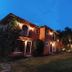 Pousada Terra Madre in Ilhabela, lit terracotta lodge exterior with arched windows and garden at dusk