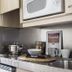 Residencia Universitaria Resa Los Abedules kitchen corner with stovetop, microwave, sink, and counter in Pamplona