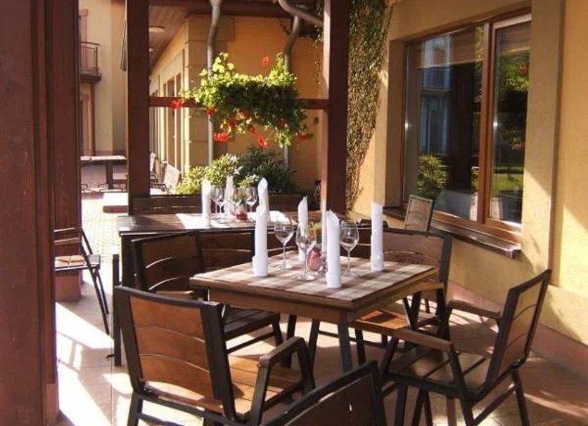 Przylądek Daglezja nad Jeziorem Kórnickim outdoor patio dining area with wooden tables and chairs in Kórnik