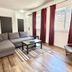 Cribs On The Hill in Picton living room with gray sectional, striped rug, wood floors and burgundy curtains