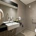 Pestana Curitiba bathroom with wall-mounted sink, toilet, grab bars and tiled shower area