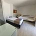 Hotel Kaamú Taganga guest room with two beds, chair, and glass table