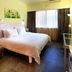 Yanjiang East Garden Inn in Guangzhou guest room with queen bed, sofa, window curtains and desk