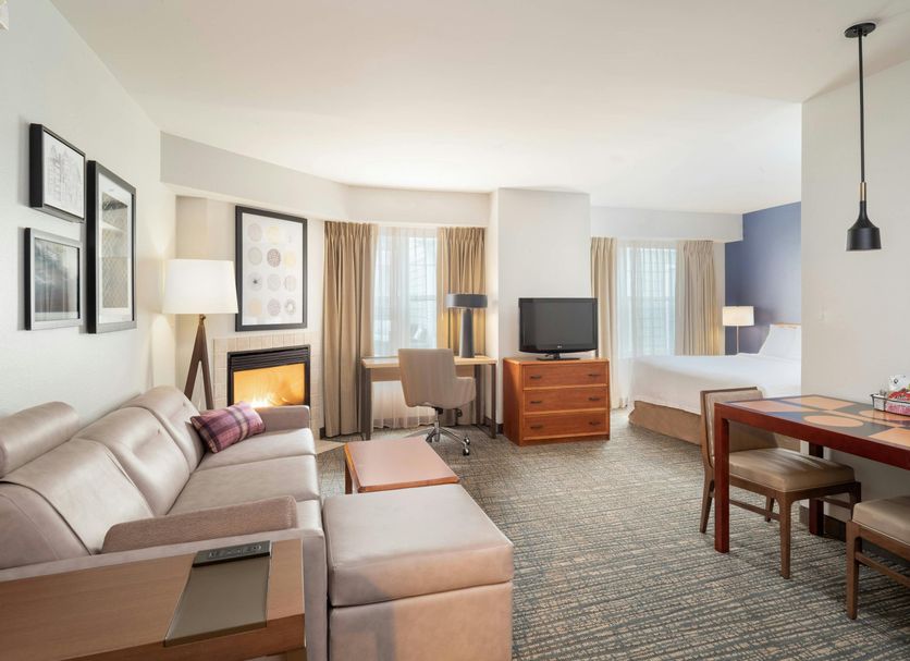 Residence Inn by Marriott New Bedford Dartmouth suite with sofa, desk, bed, and dining table