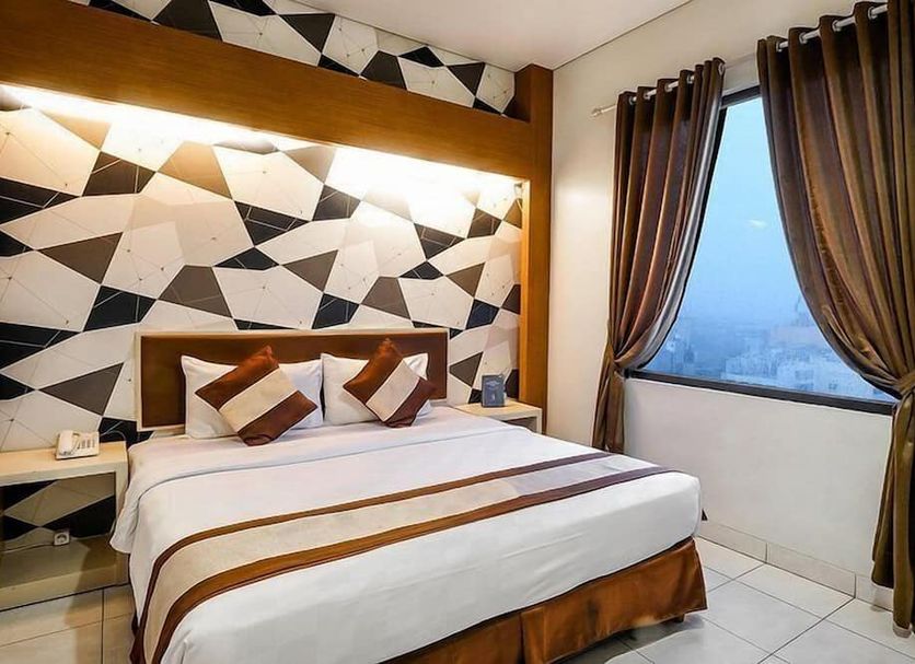 Hotel 88 Mangga Besar Viii, Jakarta: modern guest room with geometric accent wall and city view window