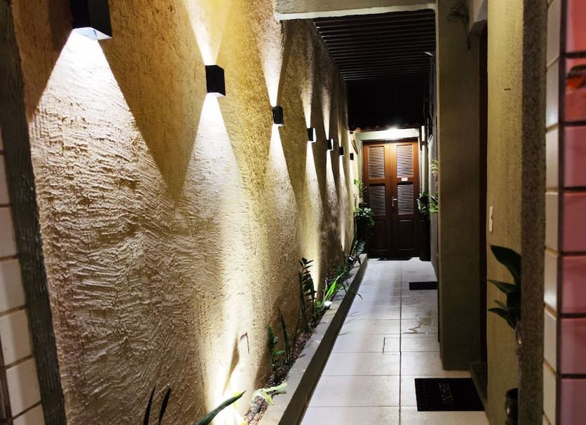 Ocean Praia Hotel in Fortaleza corridor with wall lights, potted plants, and tiled floor