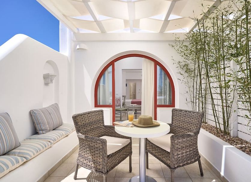 Stelia Mare Boutique Hotel in Naousa: white terrace seating area with wicker chairs, table and bamboo