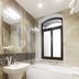 Roxen Hotel&Spa in Chisinau bathroom with bathtub, sink, large mirror, and frosted arched window