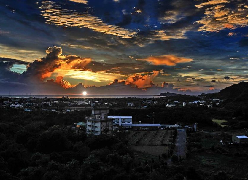 Wan Jin Hot Spring in Wanli District with dramatic sunset clouds over the coastline and hills