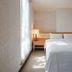The Koos Hotel in Xindian District bedroom with a king bed, bedside lamps, and soft natural light