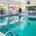 Quality Inn and Suites Ann Arbor Hwy 23 indoor pool with seating and colorful umbrellas in Ann Arbor