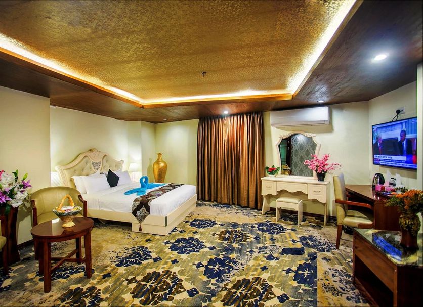 Hotel Noorjahan Grand Sylhet guest room with king bed, ornate decor, desk, TV and floral accents